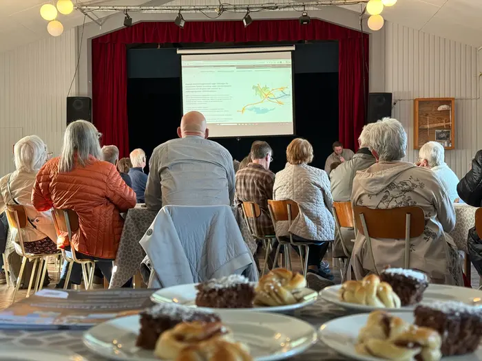 Ett rum fyllt med människor som tittar mot en projektorduk
