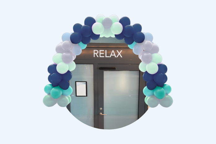 Relaxentré med skylten ”RELAX” och ballongbåge i blått, turkost och vitt.