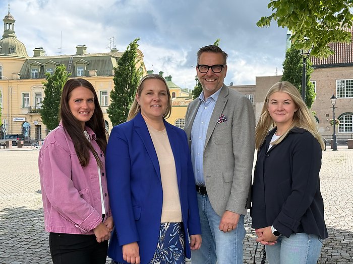 Fyra medarbetare på Köpings kommuns näringslivsavdelning står tillsammans på Stora torget i Köping.