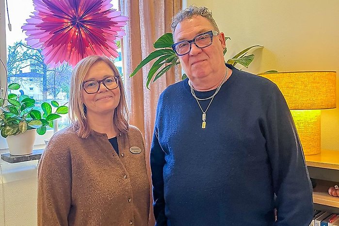 Petra och Magnus står inomhus bredvid en fönsterbräda med krukväxter och en pappersstjärna.